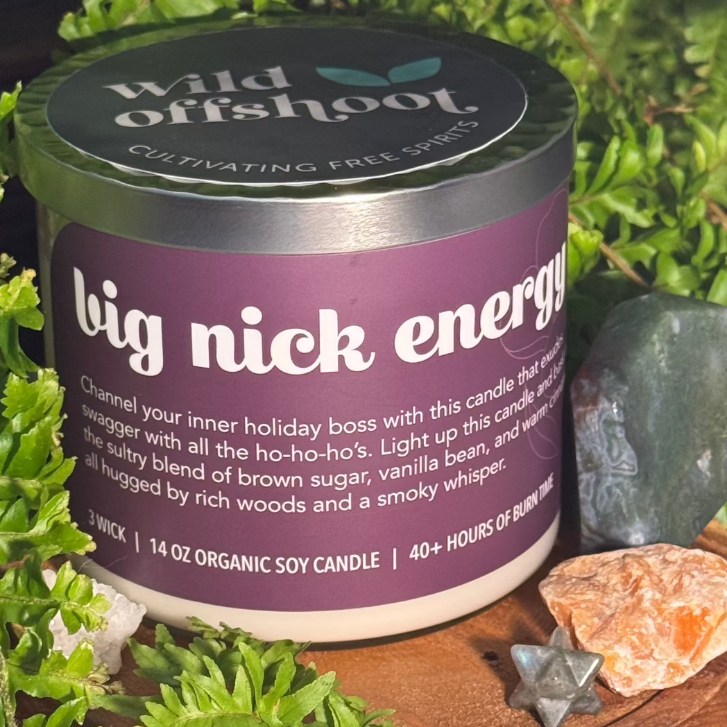 Candle candle labeled 'big nick energy' by 'wild offshoot' with a natural setting.