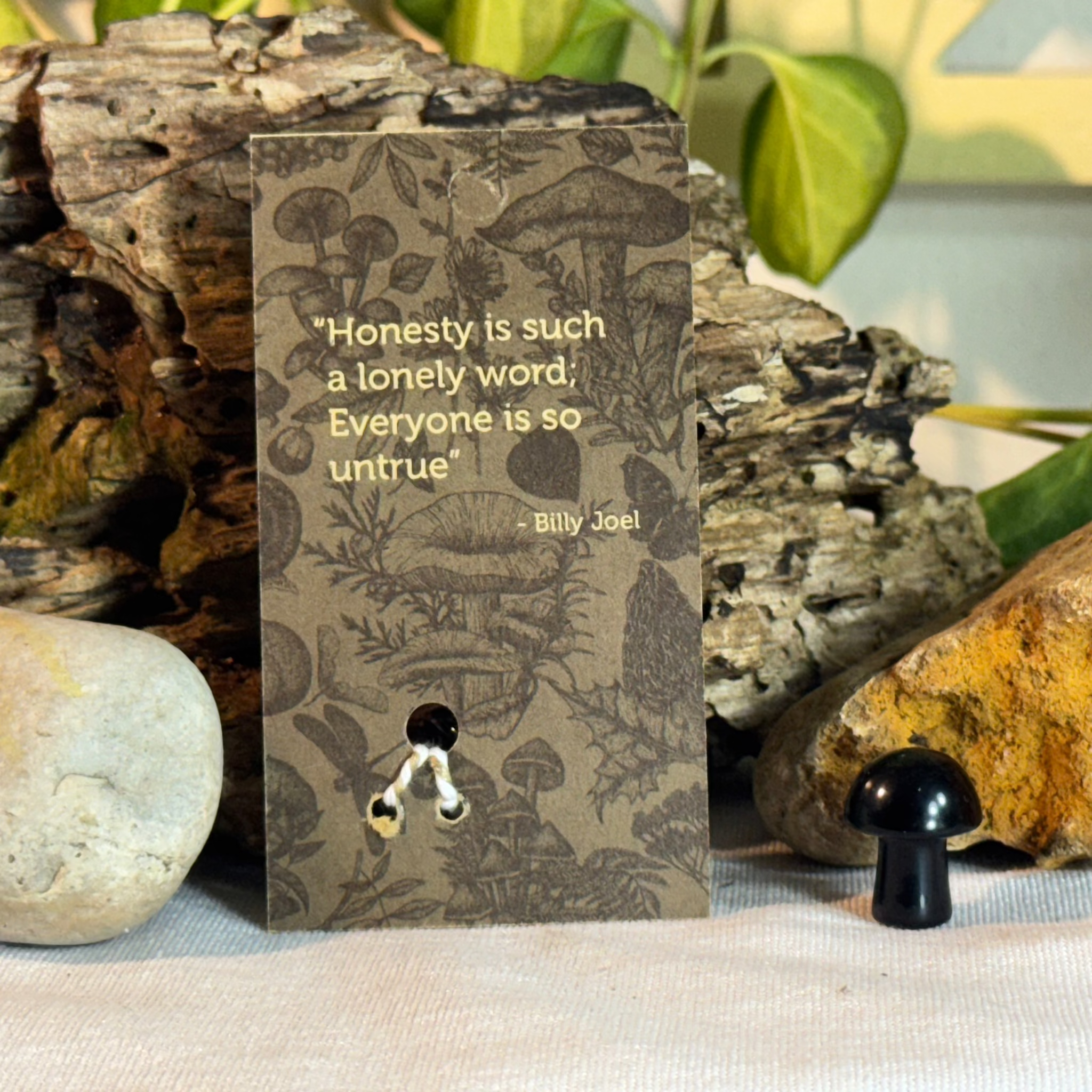 Card with mushroom design and a Billy Joel quote on a natural background