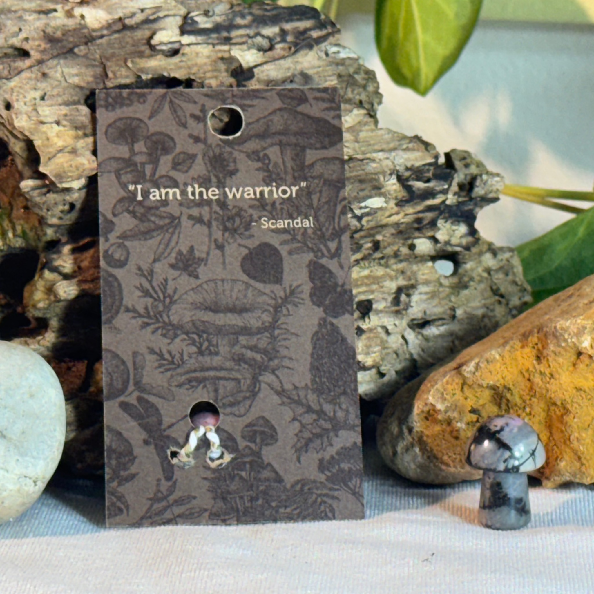 Card with mushroom design and a Scandal quote on a natural background